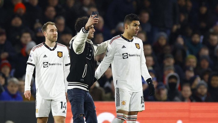 Soccer Football - Premier League - Crystal Palace v Manchester United - Selhurst Park, London, Britain - January 18, 2023 A pitch invader takes a selfie with Manchester United's Casemiro during the match Action Images via Reuters/Peter Cziborra EDITORIAL USE ONLY. No use with unauthorized audio, video, data, fixture lists, club/league logos or 'live' services. Online in-match use limited to 75 images, no video emulation. No use in betting, games or single club /league/player publications.  Please contact your account representative for further details.