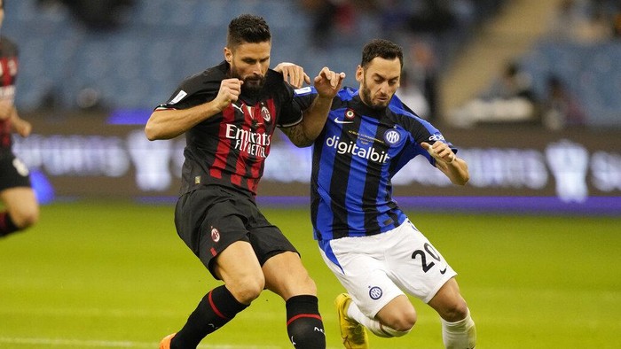 AC Milans Olivier Giroud, left, challenges for the ball with Inter Milans Hakan Calhanoglu during the Italian Super Cup final soccer match between AC Milan and Inter Milan at the King Saud University Stadium, in Riyadh, Saudi Arabia, Wednesday, Jan. 18, 2023. (AP Photo/Hussein Malla)