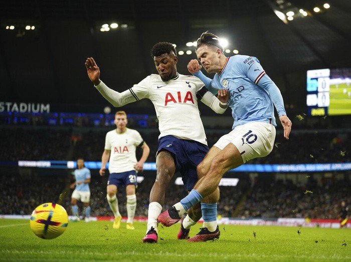 Manchester City's Jack Grealish, right, attempts a shot at goal in front of Tottenham's Emerson Royal during the English Premier League soccer match between Manchester City and Tottenham Hotspur at the Etihad Stadium in Manchester, England, Thursday, Jan. 19, 2023. (AP Photo/Dave Thompson)