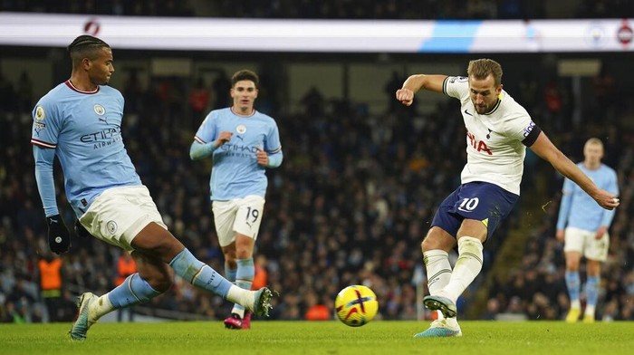 Tottenham's Harry Kane, right, attempts a shot at goal in front of Manchester City's Manuel Akanji during the English Premier League soccer match between Manchester City and Tottenham Hotspur at the Etihad Stadium in Manchester, England, Thursday, Jan. 19, 2023. (AP Photo/Dave Thompson)