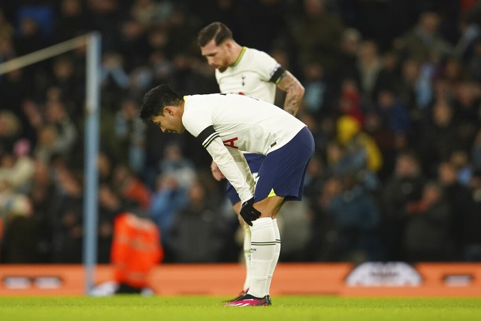 Tottenham's Son Heung-min, fore ground and Tottenham's Pierre-Emile Hojbjerg stand in dejection after Manchester City's Riyad Mahrez scores his side's fourth goal during the English Premier League soccer match between Manchester City and Tottenham Hotspur at the Etihad Stadium in Manchester, England, Thursday, Jan. 19, 2023. (AP Photo/Dave Thompson)