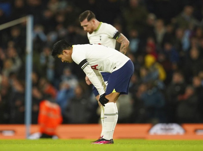 Tottenham's Son Heung-min, fore ground and Tottenham's Pierre-Emile Hojbjerg stand in dejection after Manchester City's Riyad Mahrez scores his side's fourth goal during the English Premier League soccer match between Manchester City and Tottenham Hotspur at the Etihad Stadium in Manchester, England, Thursday, Jan. 19, 2023. (AP Photo/Dave Thompson)
