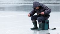 Tak Hiraukan Perang, Pria Ukraina Asyik Mancing di Sungai Beku