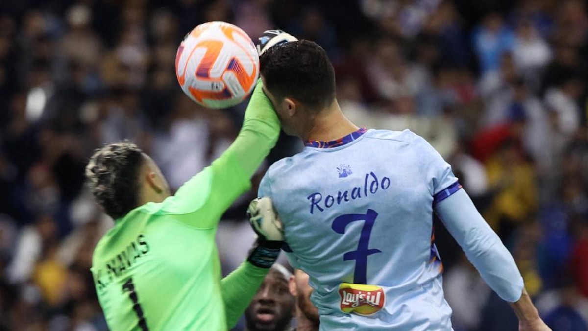 Cristiano Ronaldo sempat dibuat terkapar oleh mantan rekan setimnya, Keylor Navas di laga eskebisi antara Riyadh All Star vs PSG. (Foto: AFP/GIUSEPPE CACACE)