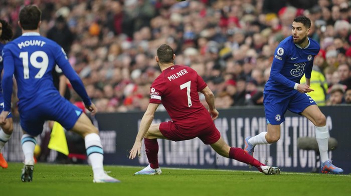 Chelseas Jorginho passes the ball next to Liverpools James Milner during the English Premier League soccer match between Liverpool and Chelsea at Anfield stadium in Liverpool, England, Saturday, Jan. 21, 2023. (AP Photo/Jon Super)