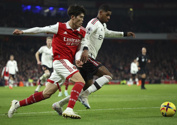 Arsenals Takehiro Tomiyasu, left, duels for the ball with Manchester Uniteds Marcus Rashford during the English Premier League soccer match between Arsenal and Manchester United at Emirates stadium in London, Sunday, Jan. 22, 2023. (AP Photo/Ian Walton)