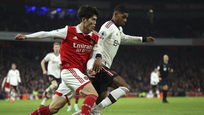 Arsenals Takehiro Tomiyasu, left, duels for the ball with Manchester Uniteds Marcus Rashford during the English Premier League soccer match between Arsenal and Manchester United at Emirates stadium in London, Sunday, Jan. 22, 2023. (AP Photo/Ian Walton)