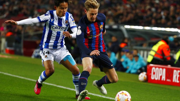 Real Sociedad's Takefusa Kubo, left, challenges for the ball with Barcelona's Frenkie de Jong during the Spanish Copa del Rey soccer match between Barcelona and Real Sociedad at the Camp Nou stadium, in Barcelona, Spain, Wednesday, Jan. 25, 2023. (AP Photo/Joan Monfort)