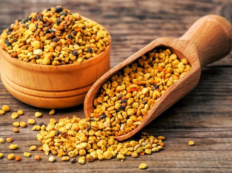 healthy bee pollen grains on wooden background