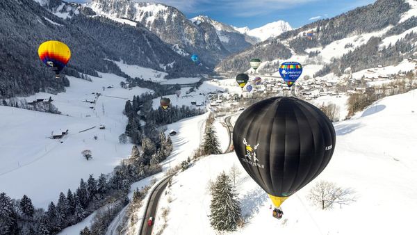 Warna-warni Balon Udara Terbang di Pegunungan Salju Swiss