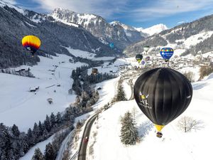 Warna-warni Balon Udara Terbang di Pegunungan Salju Swiss