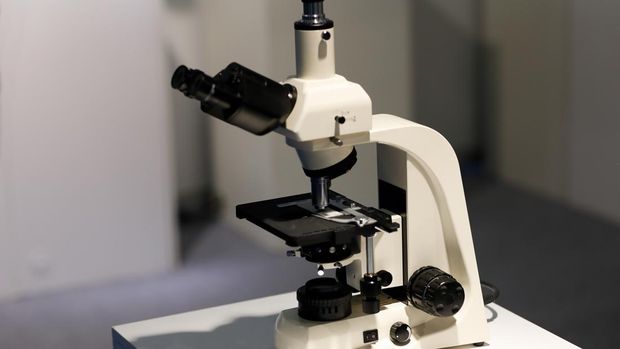 Laboratory microscope with a trinocular head. Selective focus.
