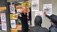 Sejumlah pengunjuk rasa yang tergabung dalam Arek Malang Bersikap menempelkan poster saat berunjuk rasa di depan Kantor Tim Arema FC, Jalan Mayjen Panjaitan, Malang, Jawa Timur, Minggu (29/1/2023).