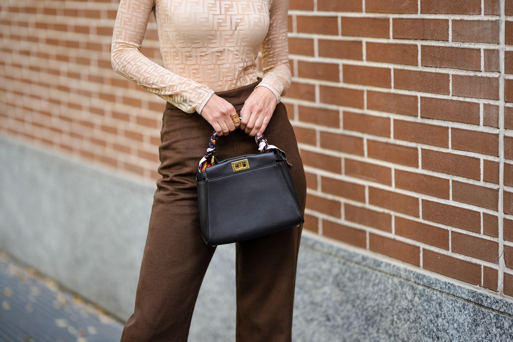 PARIS, FRANCE - OCTOBER 03: Xiayan wears a beige with pale yellow leopard print pattern high waist long skirt, a silver 1969 Nano metal-disc shoulder bag from Paco Rabanne, outside Zimmermann, Paris Fashion Week - Womenswear Spring/Summer 2023, on October 03, 2022 in Paris, France. (Photo by Edward Berthelot/Getty Images)