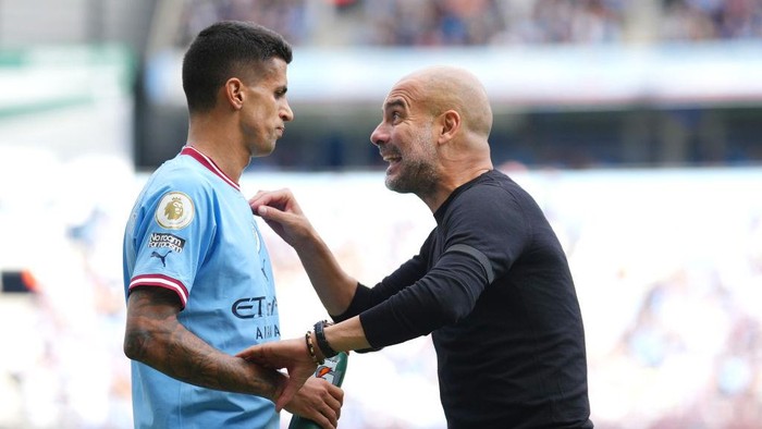 MANCHESTER, ENGLAND - OCTOBER 02: Pep Guardiola, Manager of Manchester City, gives instructions to their side Joao Cancelo of Manchester City during the Premier League match between Manchester City and Manchester United at Etihad Stadium on October 02, 2022 in Manchester, England. (Photo by Tom Flathers/Manchester City FC via Getty Images)