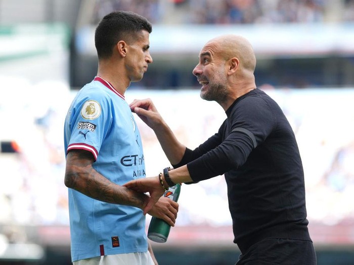 MANCHESTER, ENGLAND - OCTOBER 02: Pep Guardiola, Manager of Manchester City, gives instructions to their side Joao Cancelo of Manchester City during the Premier League match between Manchester City and Manchester United at Etihad Stadium on October 02, 2022 in Manchester, England. (Photo by Tom Flathers/Manchester City FC via Getty Images)