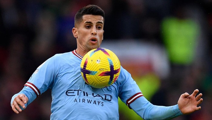 Manchester Citys Portuguese defender Joao Cancelo controls the ball during the English Premier League football match between Manchester United and Manchester City at Old Trafford in Manchester, north west England, on January 14, 2023. - RESTRICTED TO EDITORIAL USE. No use with unauthorized audio, video, data, fixture lists, club/league logos or live services. Online in-match use limited to 120 images. An additional 40 images may be used in extra time. No video emulation. Social media in-match use limited to 120 images. An additional 40 images may be used in extra time. No use in betting publications, games or single club/league/player publications. (Photo by Oli SCARFF / AFP) / RESTRICTED TO EDITORIAL USE. No use with unauthorized audio, video, data, fixture lists, club/league logos or live services. Online in-match use limited to 120 images. An additional 40 images may be used in extra time. No video emulation. Social media in-match use limited to 120 images. An additional 40 images may be used in extra time. No use in betting publications, games or single club/league/player publications. / RESTRICTED TO EDITORIAL USE. No use with unauthorized audio, video, data, fixture lists, club/league logos or live services. Online in-match use limited to 120 images. An additional 40 images may be used in extra time. No video emulation. Social media in-match use limited to 120 images. An additional 40 images may be used in extra time. No use in betting publications, games or single club/league/player publications. (Photo by OLI SCARFF/AFP via Getty Images)