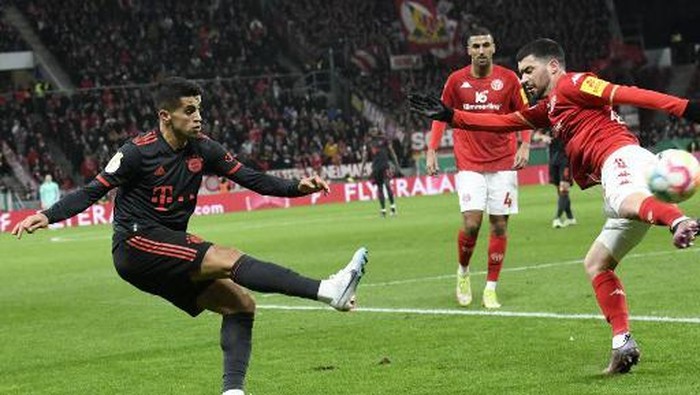 Mainz Spanish defender Aaron Martin (R) and Bayern Munichs Portuguese defender Joao Cancelo vie for the ball during the German Cup (DFB Pokal) last 16 football match between 1 FSV Mainz 05 and FC Bayern Munich in Mainz, southwestern Germany on February 1, 2023. (Photo by THOMAS KIENZLE / AFP) / DFB REGULATIONS PROHIBIT ANY USE OF PHOTOGRAPHS AS IMAGE SEQUENCES AND QUASI-VIDEO.