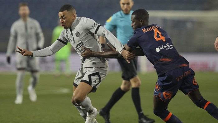 PSG's Kylian Mbappe, left, is challenged by Montpellier's Boubakar Kouyate during the French League One soccer match between Montpellier and Paris Saint-Germain at the State La Mosson stadium in Montpellier, France, Wednesday, Feb. 1, 2023. (AP Photo/Thibault Camus)