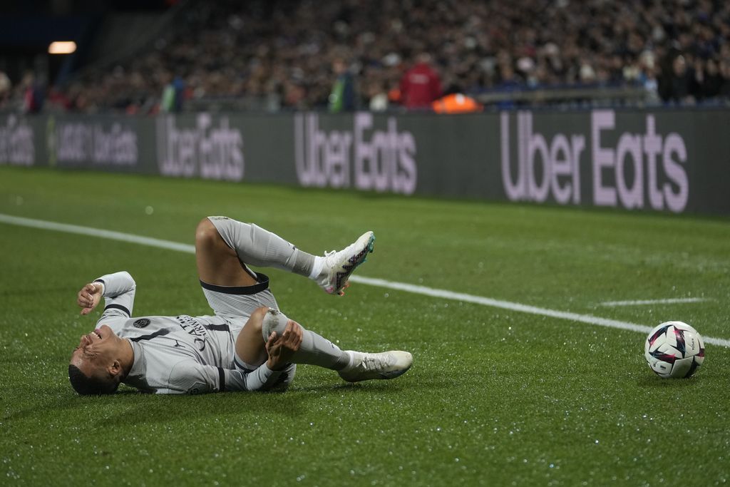 Injured PSG's Kylian Mbappe grimaces in pain during the French League One soccer match between Montpellier and Paris Saint-Germain at the State La Mosson stadium in Montpellier, France, Wednesday, Feb. 1, 2023. (AP Photo/Thibault Camus)