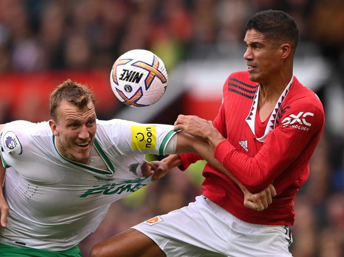 MANCHESTER, ENGLAND - OCTOBER 16: Newcastle United defender Dan Burn has his shirt pulled by Manchester United defender Raphael Varane during the Premier League match between Manchester United and Newcastle United at Old Trafford on October 15, 2022 in Manchester, England. (Photo by Stu Forster/Getty Images)
