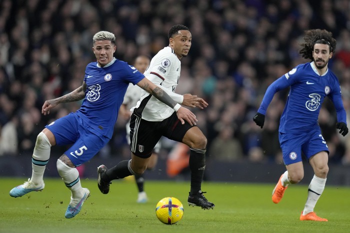 Fulhams Kenny Tete drives the ball past Chelseas Enzo Fernandez, left, and Marc Cucurella, right, during the English Premier League soccer match between Chelsea and Fulham at Stamford Bridge stadium in London, Friday, Feb. 3, 2023. (AP Photo/Kirsty Wigglesworth)