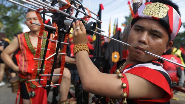 Seorang Tatung (dukun Tionghoa yang kerasukan arwah leluhur) menancapkan beberapa besi ke mulutnya saat beratraksi dalam pawai perayaan Cap Go Meh 2574 di Kota Singkawang, Kalimantan Barat, Minggu (5/2/2023). Perayaan Cap Go Meh yang dimeriahkan dengan atraksi ratusan tatung dan seni budaya Tionghoa lainnya tersebut kembali digelar di Kota Singkawang setelah sebelumnya vakum selama dua tahun karena pandemi COVID-19. ANTARA FOTO/Jessica Helena Wuysang/tom.