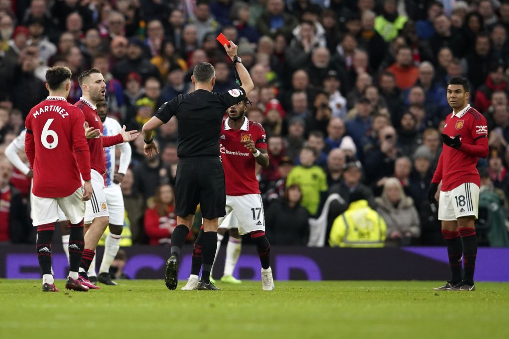 Referee Andre Marriner shows a red card to Manchester United's Casemiro, right, during the English Premier League soccer match between Manchester United and Crystal Palace, at the Old Trafford stadium in Manchester, England, Saturday, Feb. 4, 2023. (AP Photo/Dave Thompson)