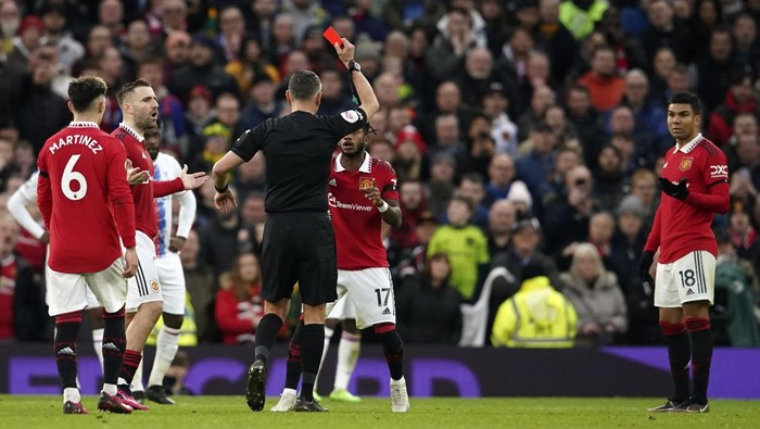 Referee Andre Marriner shows a red card to Manchester Uniteds Casemiro, right, during the English Premier League soccer match between Manchester United and Crystal Palace, at the Old Trafford stadium in Manchester, England, Saturday, Feb. 4, 2023. (AP Photo/Dave Thompson)