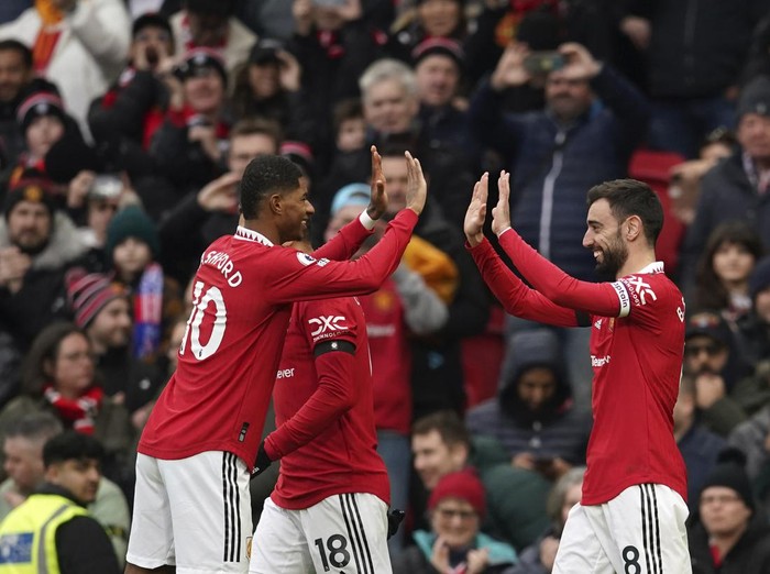 Manchester United's Bruno Fernandes celebrates with teammates after scoring his side's opening goal during the English Premier League soccer match between Manchester United and Crystal Palace, at the Old Trafford stadium in Manchester, England, Saturday, Feb. 4, 2023. (AP Photo/Dave Thompson)