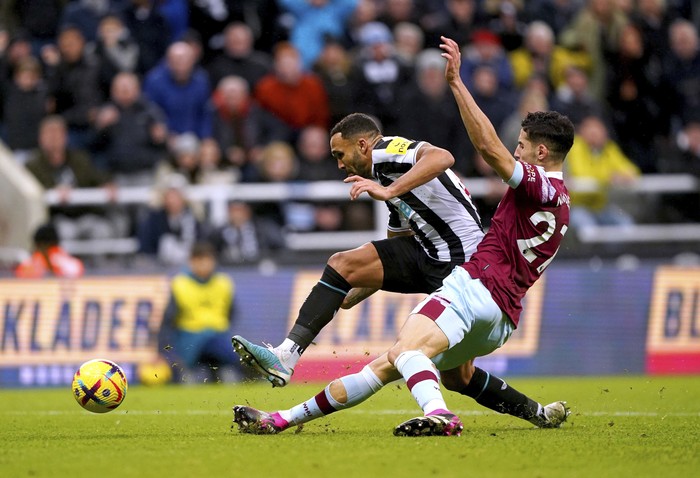 Newcastle United's Callum Wilson, right, and West Ham United's Nayef Aguerd battle for the ball, during the English Premier League soccer match between Newcastle United and West Ham United, at St. James' Park, in Newcastle upon Tyne, England, Saturday, Feb. 4, 2023. (Owen Humphreys/PA via AP)