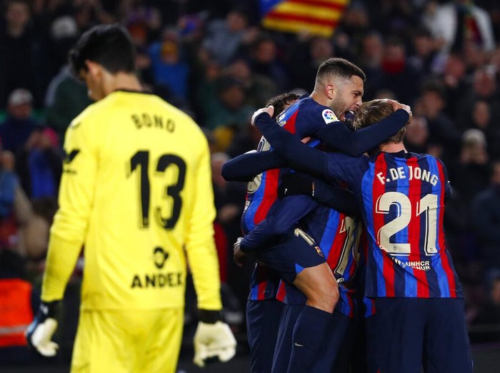 Barcelona's Jordi Alba, top, celebrates with his teammates after scoring his side's opening goal during a Spanish La Liga soccer match between Barcelona and Sevilla at the Camp Nou stadium in Barcelona, Spain, Sunday, Feb. 5, 2023. (AP Photo/Joan Monfort)
