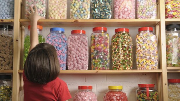 Ilustrasi anak mengambil permen Produk dengan pemanis buatan berlebihan termasuk jenis makanan perusak konsentrasi anak.