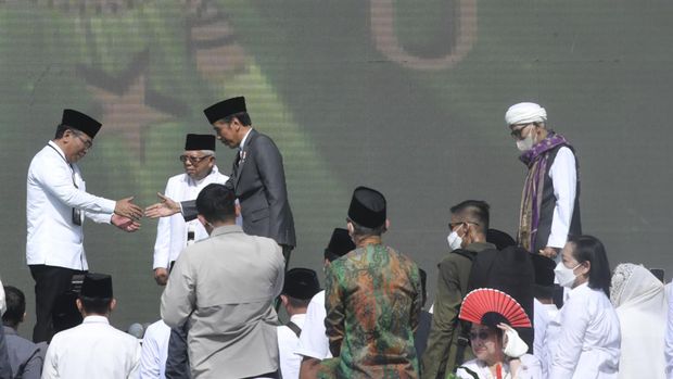 Presiden Joko Widodo (ketiga kiri) didampingi Wakil Presiden Ma'ruf Amin (kedua kiri) bersalaman dengan Ketua Umum Pengurus Besar Nahdlatul Ulama (PBNU), Yahya Cholil Staquf (kiri) disaksikan Rais 'Aam PBNU Miftachul Akhyar (kanan) usai memukul bedug digital saat membuka Puncak Resepsi Harlah 1 Abad NU di Stadion Gelora Delta Sidoarjo, Jawa Timur, Rabu (7/2/2023). Kegiatan nan bakal digelar selama 24 jam tersebut diisi beragam aktivitas seperti ritual keagamaan, resepsi puncak harlah, karnaval nusantara, panggung intermezo rakyat, pagelaran UMKM hingga kuliner nusantara. ANTARA FOTO/Zabur Karuru/hp.