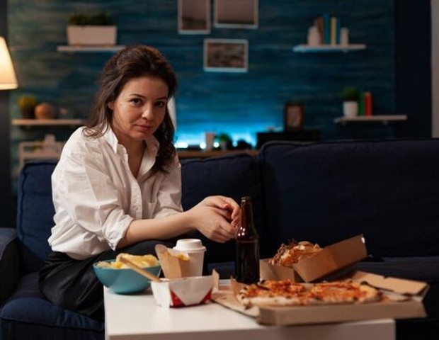 Perempuan sedang menikmati snack di malam hari