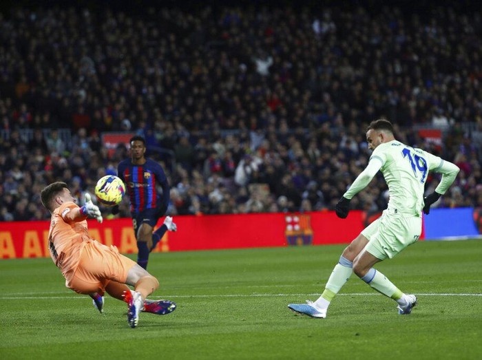 Barcelona's goalkeeper Marc-Andre ter Stegen, left, makes a save in front Getafe's Borja Mayoral during a Spanish La Liga soccer match between Barcelona and Getafe at the Camp Nou stadium in Barcelona, Spain, Sunday, Jan. 22, 2023. (AP Photo/Joan Monfort)