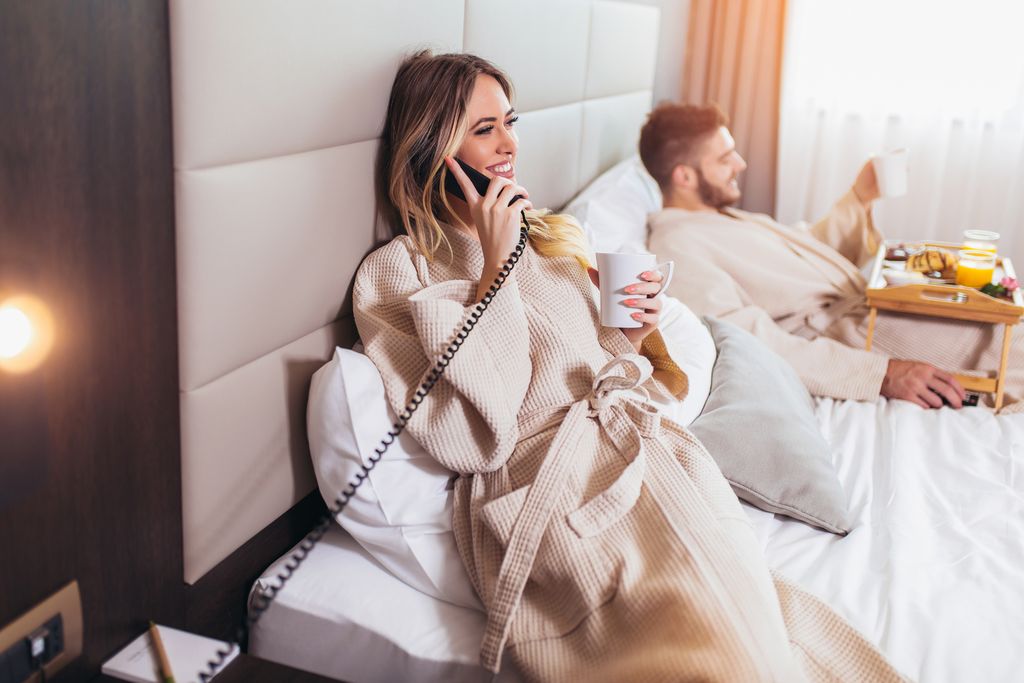 Woman calling room service for food from hotel room