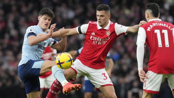 Arsenals Granit Xhaka, centre, and Brentfords Christian Norgaard challenge for the ball during the English Premier League soccer match between Arsenal and Brentford at Emirates stadium in London, Saturday, Feb. 11, 2023. (AP Photo/Frank Augstein)
