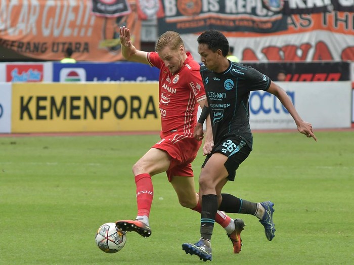 Pesepak Bola Persija Jakarta Aji Kusuma (kanan) dijaga ketat pesepak bola Arema Fc Sergio Domingos (kiri) saat mengoper bola pada lanjutan Liga 1 di Stadion Patriot Chandrabhaga, di Bekasi, Jawa Barat, Minggu (12/2/2023). Persija Jakarta menang dengan skor 2-0.