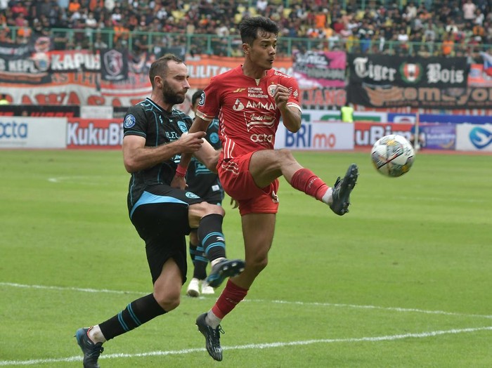 Pesepak Bola Persija Jakarta Aji Kusuma (kanan) dijaga ketat pesepak bola Arema Fc Sergio Domingos (kiri) saat mengoper bola pada lanjutan Liga 1 di Stadion Patriot Chandrabhaga, di Bekasi, Jawa Barat, Minggu (12/2/2023). Persija Jakarta menang dengan skor 2-0.