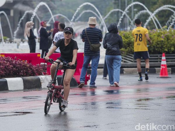 Salut! Warga Berolahraga saat Rintik Hujan Mengguyur Jakarta