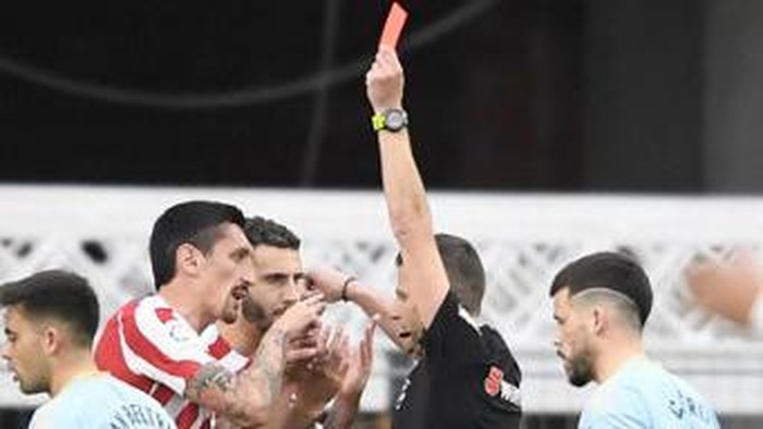 Atletico Madrids Montenegrin defender Stefan Savic (L) receives a red card during the Spanish League football match between RC Celta de Vigo and Club Atletico de Madrid at the Balaidos stadium in Vigo on February 12, 2023. (Photo by MIGUEL RIOPA / AFP)