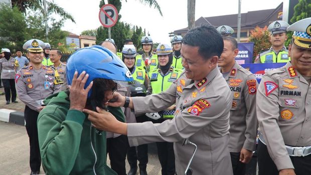 Kapolda Banten Irjen Rudy Heriyanto membagikan helm gratis ke pemotor yang berkendara tanpa helm.