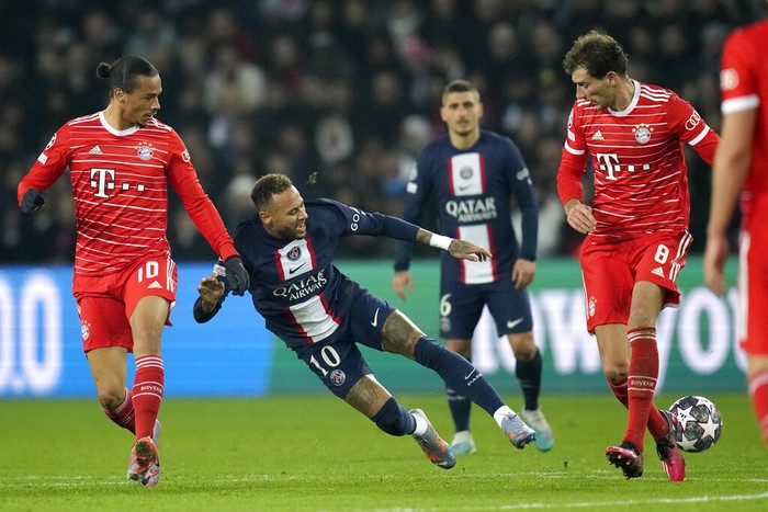 PSGs Neymar, center, duels for the ball with Bayerns Leroy Sane, left, and Bayerns Leon Goretzka during the Champions League round of 16 first leg soccer match between Paris Saint Germain and Bayern Munich, at the Parc des Princes stadium, in Paris, France, Tuesday, Feb. 14, 2023. (AP Photo/Christophe Ena)