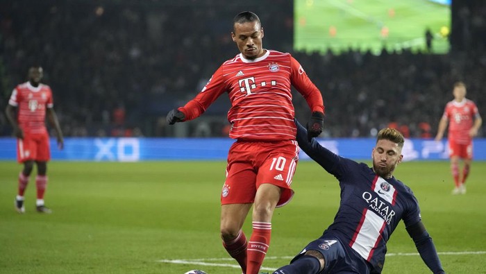 Bayerns Leroy Sane, left, duels for the ball with PSGs Sergio Ramos during the Champions League round of 16 first leg soccer match between Paris Saint Germain and Bayern Munich, at the Parc des Princes stadium, in Paris, France, Tuesday, Feb. 14, 2023. (AP Photo/Christophe Ena)