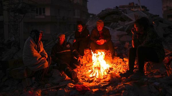 Warga Turki Menghangatkan Diri di Antara Reruntuhan Bangunan