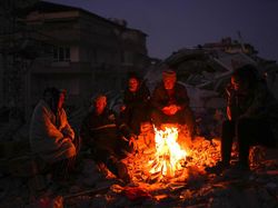 Warga Turki Menghangatkan Diri di Antara Reruntuhan Bangunan