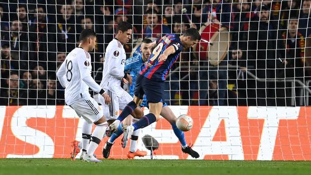 BARCELONA, SPAIN - FEBRUARY 16: Raphinha (not pictured) scores the team's second goal as Robert Lewandowski of FC Barcelona stretches for the ball during the UEFA Europa League knockout round play-off leg one match between FC Barcelona and Manchester United at Spotify Camp Nou on February 16, 2023 in Barcelona, Spain. (Photo by David Ramos/Getty Images)