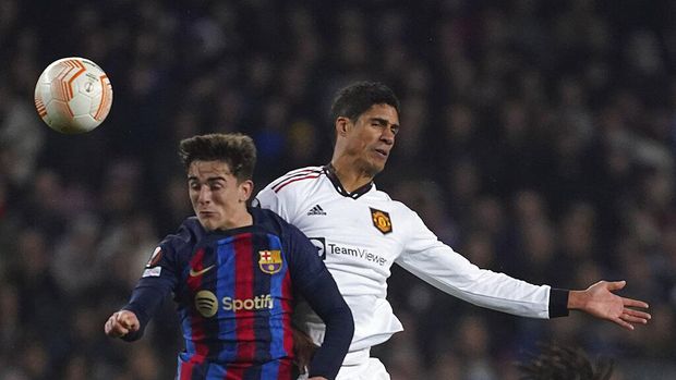 Barcelona's Gavi, left, and Manchester United's Raphael Varane jump for the ball during the Europa League playoff first leg soccer match between Barcelona and Manchester United at the Camp Nou stadium in Barcelona, Spain, Thursday, Feb. 16, 2023. (AP Photo/Joan Mateu Parra)