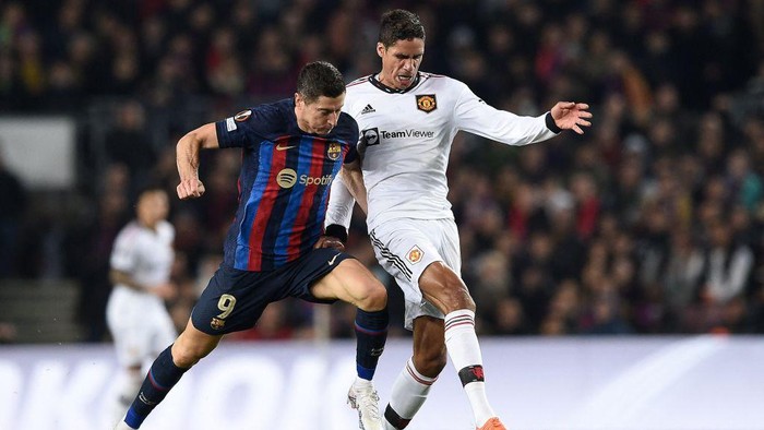 Barcelonas Polish forward Robert Lewandowski (L) fights for the ball with Manchester Uniteds French defender Raphael Varane during the UEFA Europa League round of 32 first-leg football match between FC Barcelona and Manchester United at the Camp Nou stadium in Barcelona, on February 16, 2023. (Photo by Josep LAGO / AFP) (Photo by JOSEP LAGO/AFP via Getty Images)